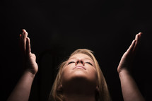 a woman looking up to God with raised hands 