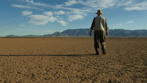 A man stands in wonder on a barren dry lake in the desert