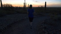 A woman talking a leisurely walk in the desert at dusk 