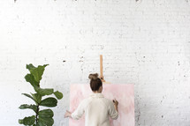 A woman painting on a canvas 