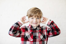 a boy child wearing headphones and smiling