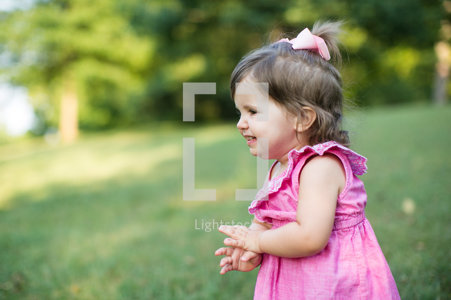 a toddler girl outdoors in summer 