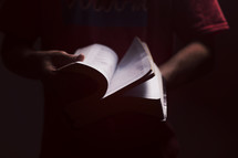 man flipping through the pages of a Bible 