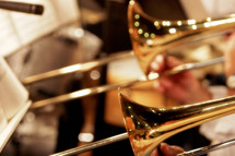 Close-up of trombones playing in a church worship band or church orchestra - focus point on foreground trombone.