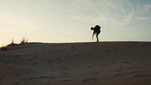 Photographer On A Sand Dune At Sunset