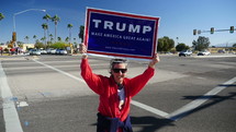 A woman waving a Trump sign at a campaign rally
