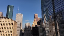 Drone view flying in towards skyscraper buildings in downtown city of Houston, Texas on beautiful blue sky no clouds morning.