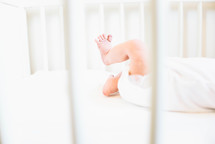 newborn baby feet in a crib 