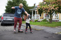 a father teaching his son to rollerblade 