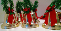 Five Christmas Bells surrounded with red and green Christmas decorations. 
