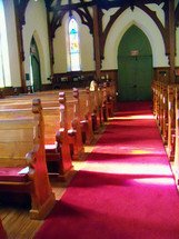 red carpet on the aisle in a church with pews 
