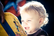toddler girl reading a book about music - singing