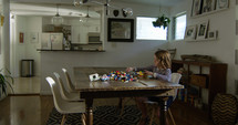 a child with building blocks at a dining room table 