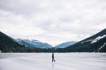 a woman walking across a frozen lake in winter in Canada 