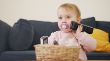Cute baby playing with a remote control a telephone