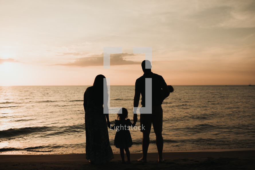 a family on a beach at sunset 