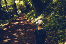 a boy exploring a path in a forest 