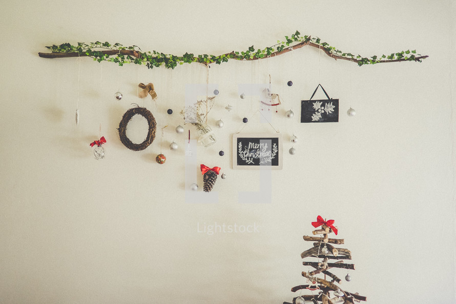 frames and ornaments hanging on a wall and a Christmas tree 