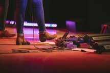 a woman's foot on a guitar pedal on stage 