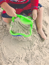 boy playing in the sand at the beach 