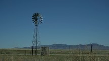 A traditional ranch windmill on grazing land out west