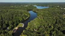 Aerial view of connecting lakes with boats and green trees on a beautiful sunny summer day.