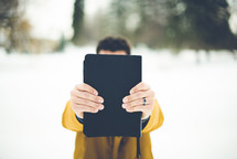 a man walking in snow carrying a Bible 