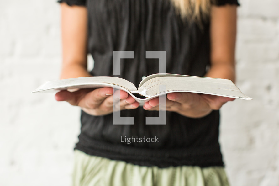 torso of a teen girl reading a Bible 