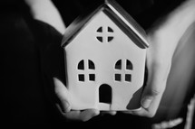 cupped hands holding a small house 