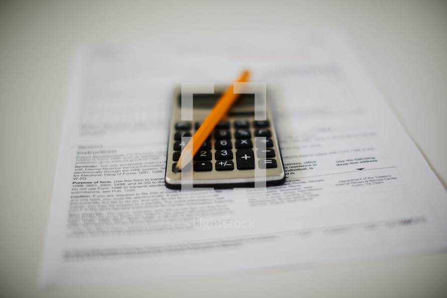 closeup of calculator and pencil on a tax form