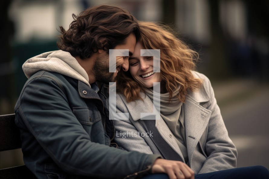 Portrait of a happy young couple sitting on a bench in the city