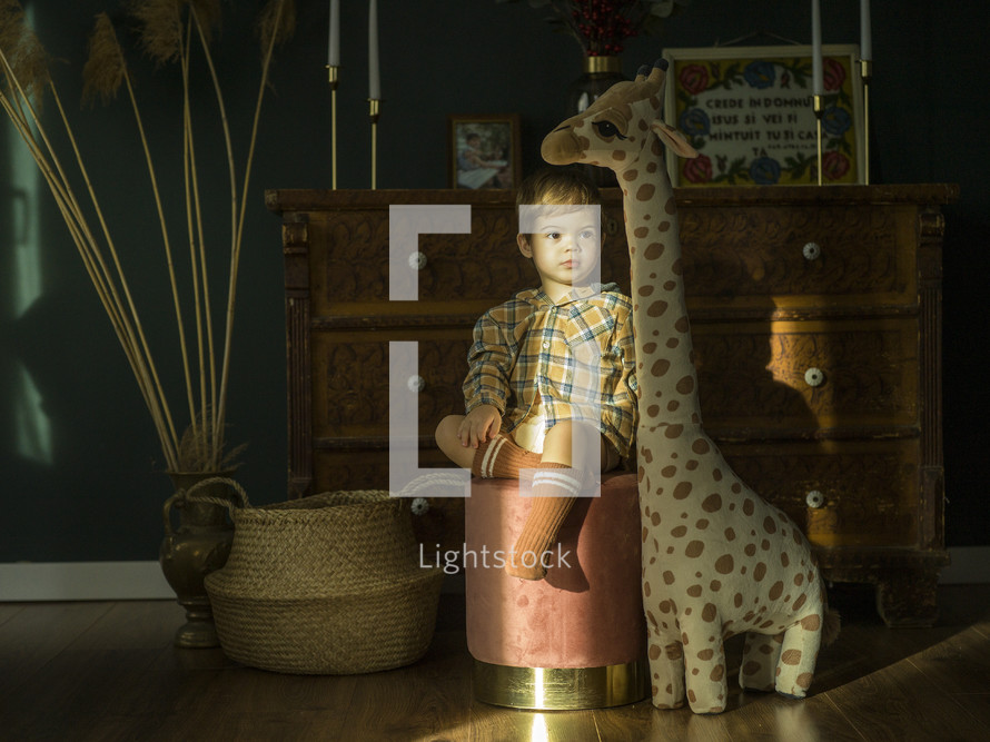 child with giraffe stuffed animal 