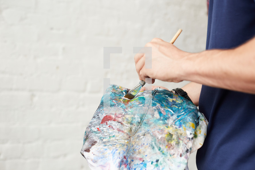 a man holding an apron covered in paint 