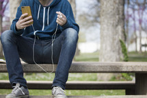 a man listening to a podcast outdoors 