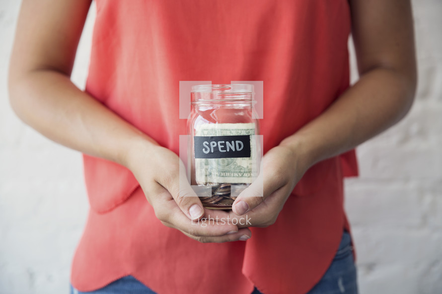 woman holding a spend money jar