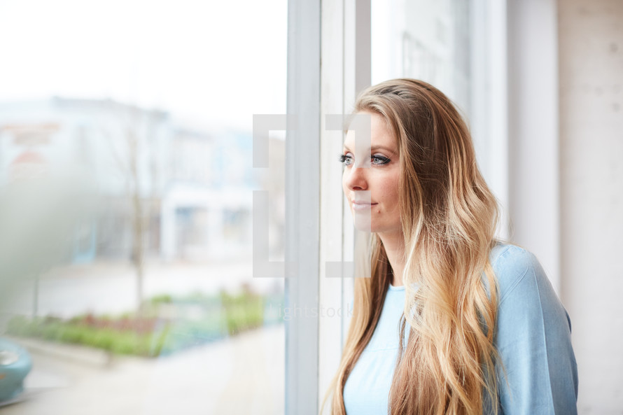 a woman standing in front of a window 
