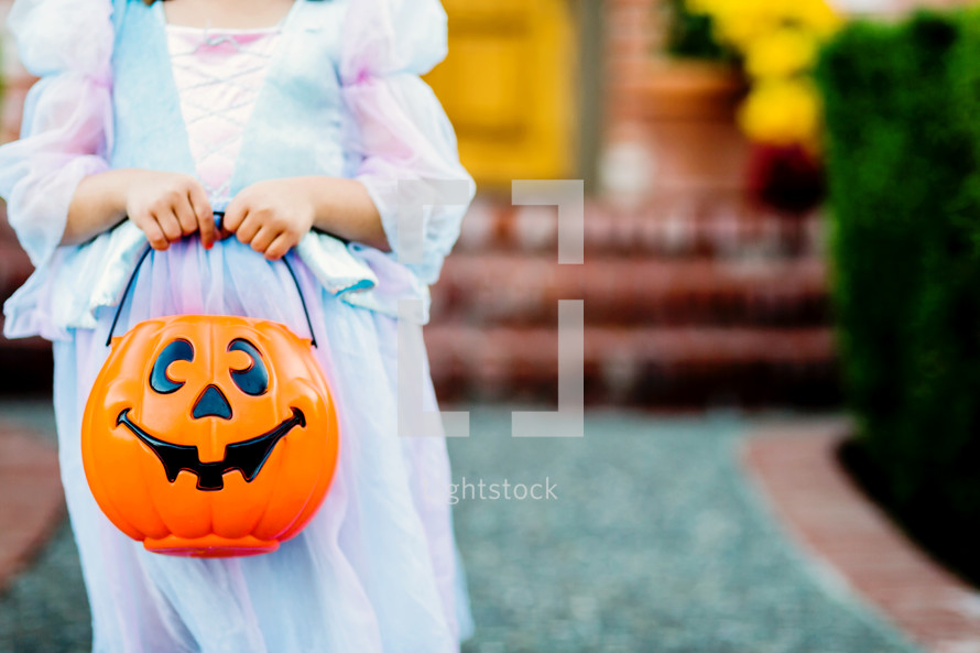 a child in a princess costume trick or treating 