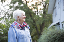 side profile of an elderly woman standing outdoors 