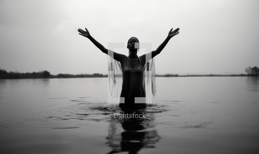 Baptism. Black and white portrait of a young black woman standing in the water in worship