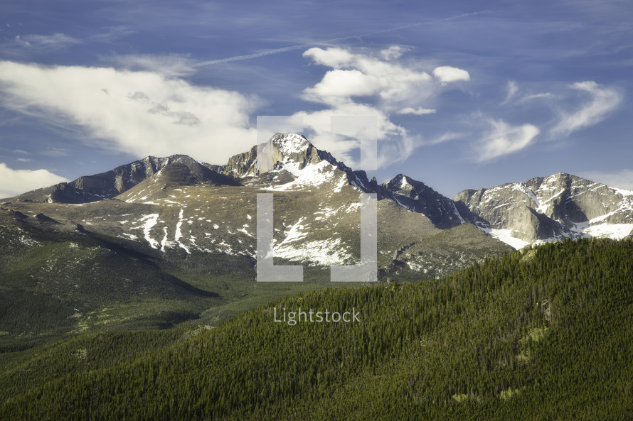 White Puffy Clouds Swirl Over the Peak of Longs Peak in Rocky Mountain National Park on a Summer day