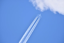 Airplane flying in the clear blue sky heading to clouds