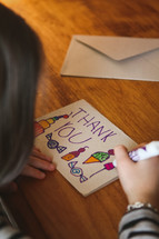 a child drawing a thank you card 