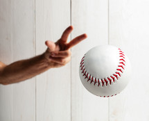 Baseball pitcher, close up of the hand ready to pitch on black background.