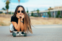 young woman lying on a skateboard 