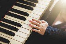 Close up of hand of girl toddler playing the piano.