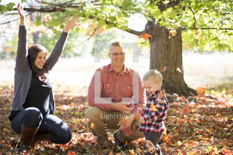 family playing in fall leaves 