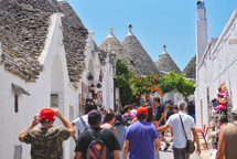 tourists and Trulli houses from the beautiful town Alberobello, Apulia, Italy
