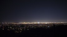 Timelapse of traffic and stars from a city overlook at night
