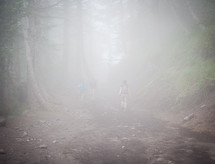Man hiking through the misty woods.