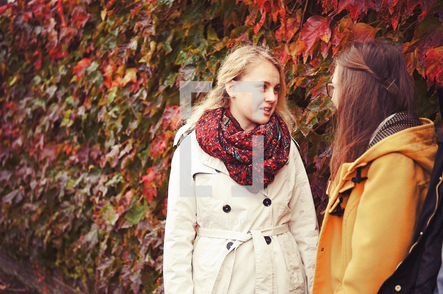 teen girls talking outdoors on a fall day 